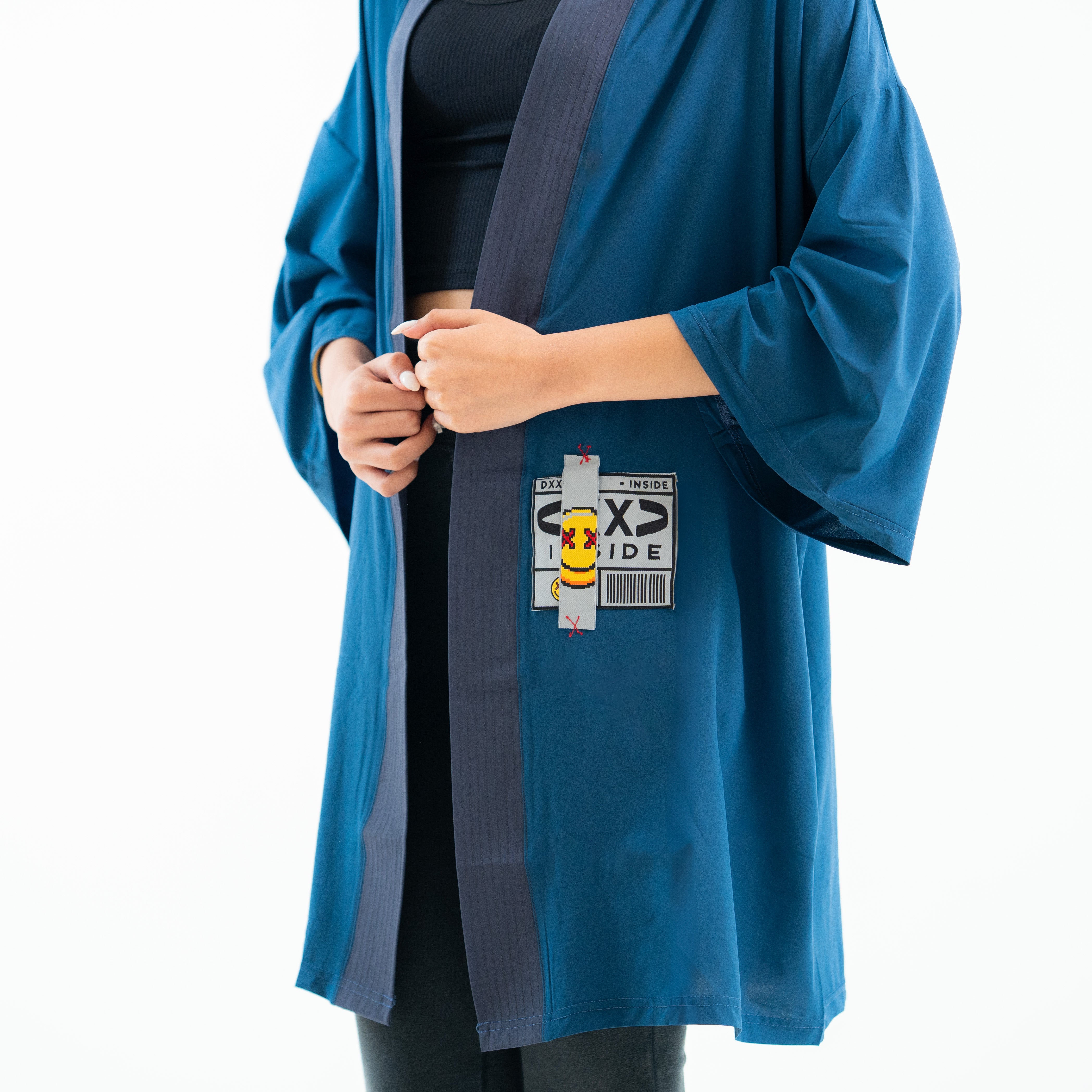 Blue raincoat with a character patch on a white background