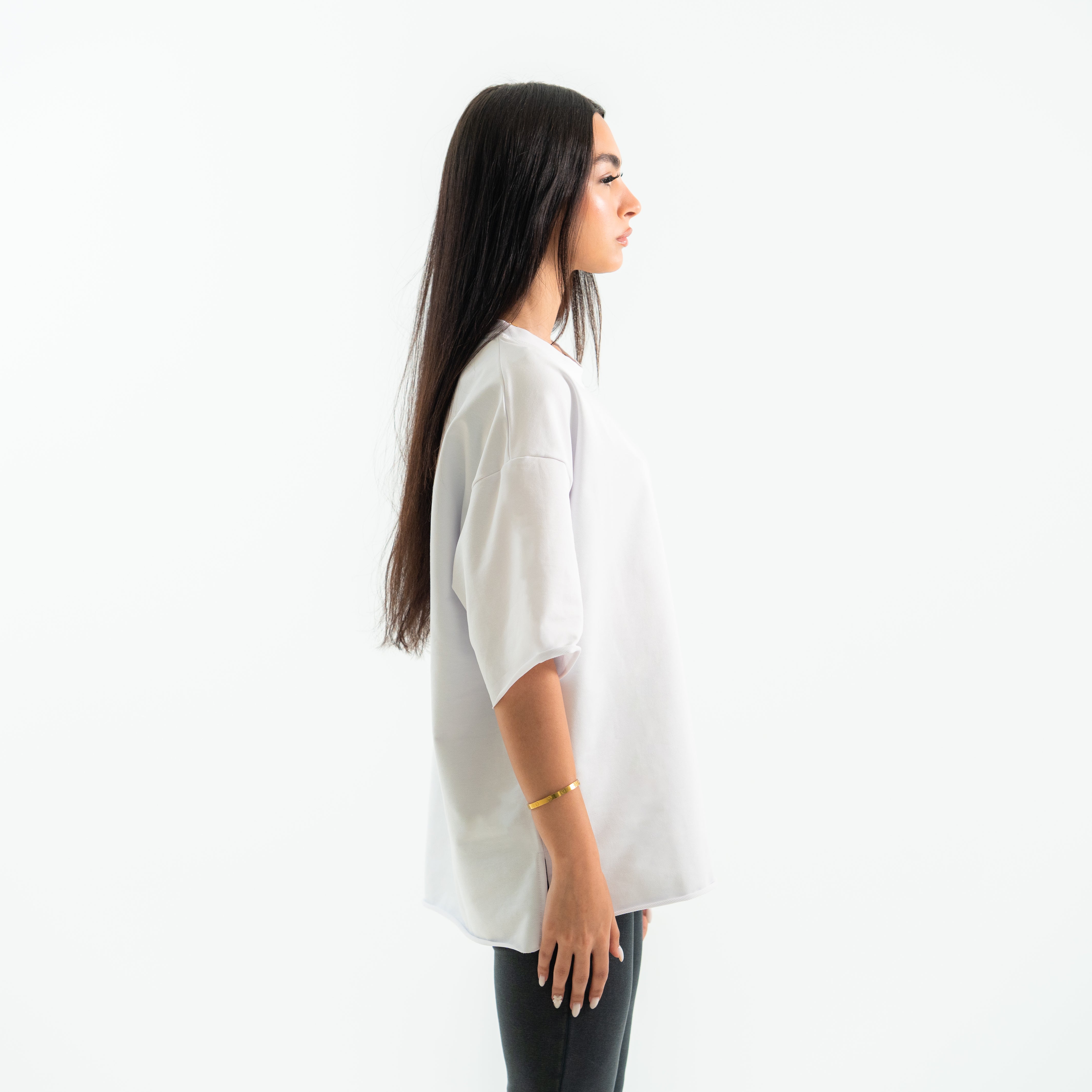 Woman wearing a white oversized shirt on a white background