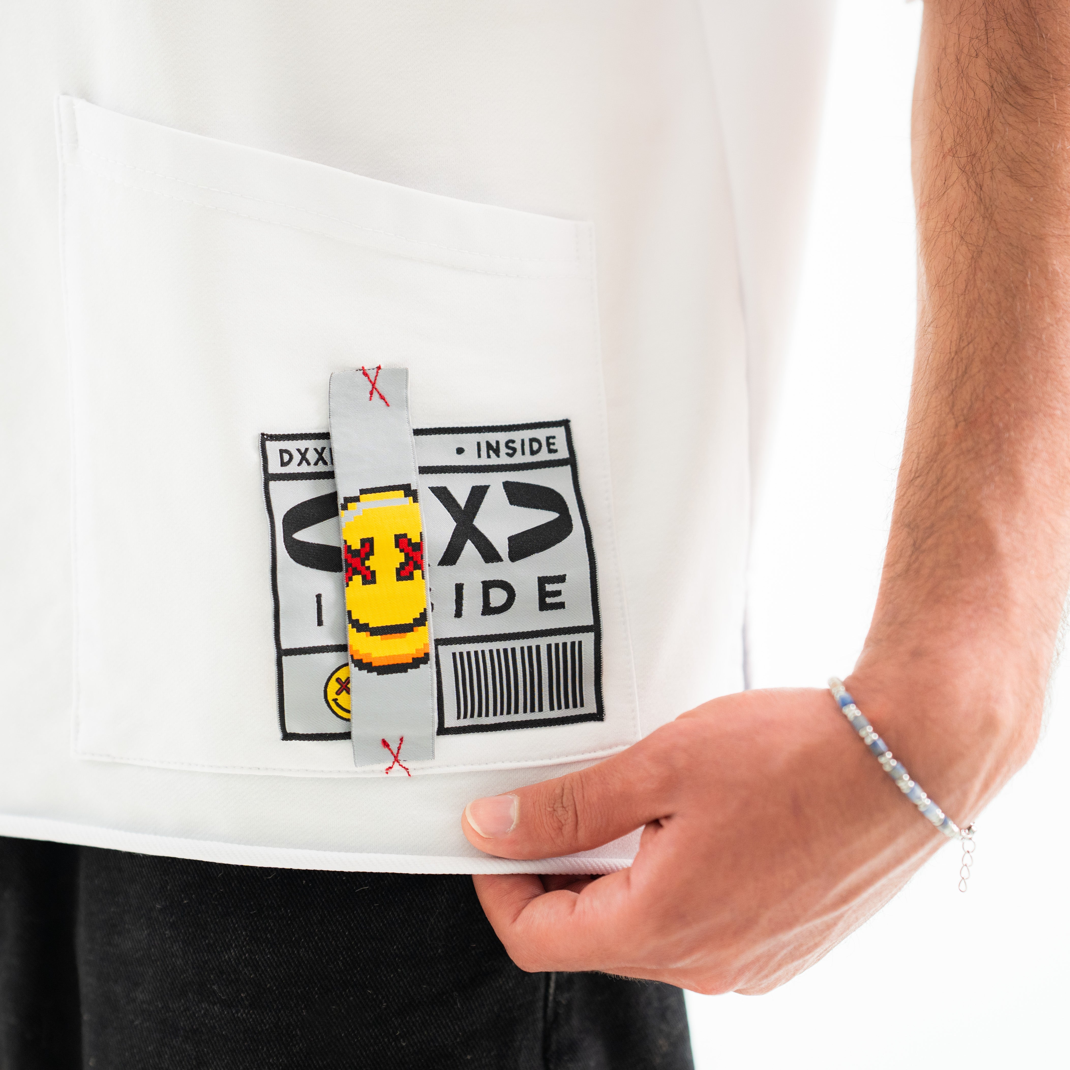 Person holding a white t-shirt with graphic design and text