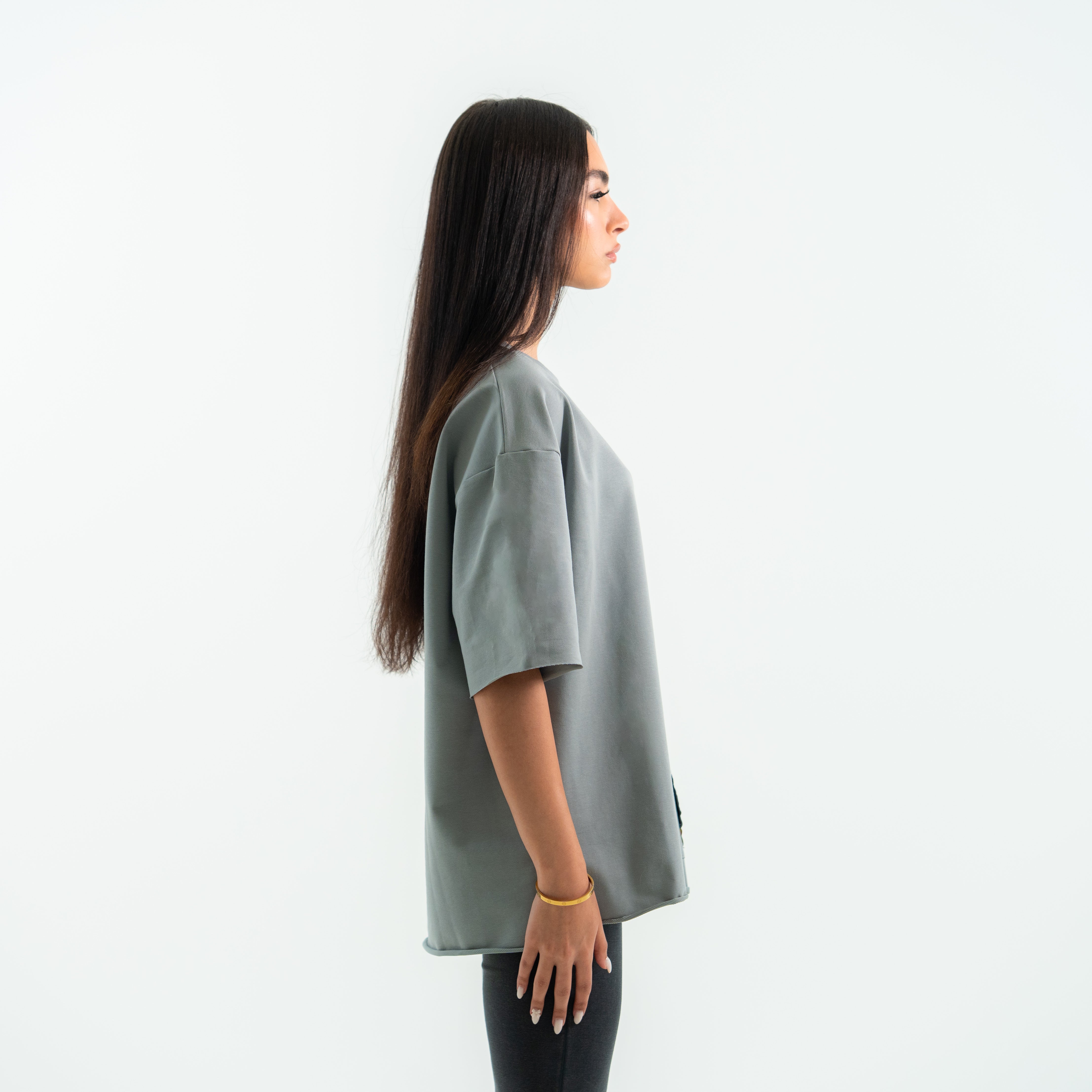 Woman wearing a gray oversized t-shirt on a white background
