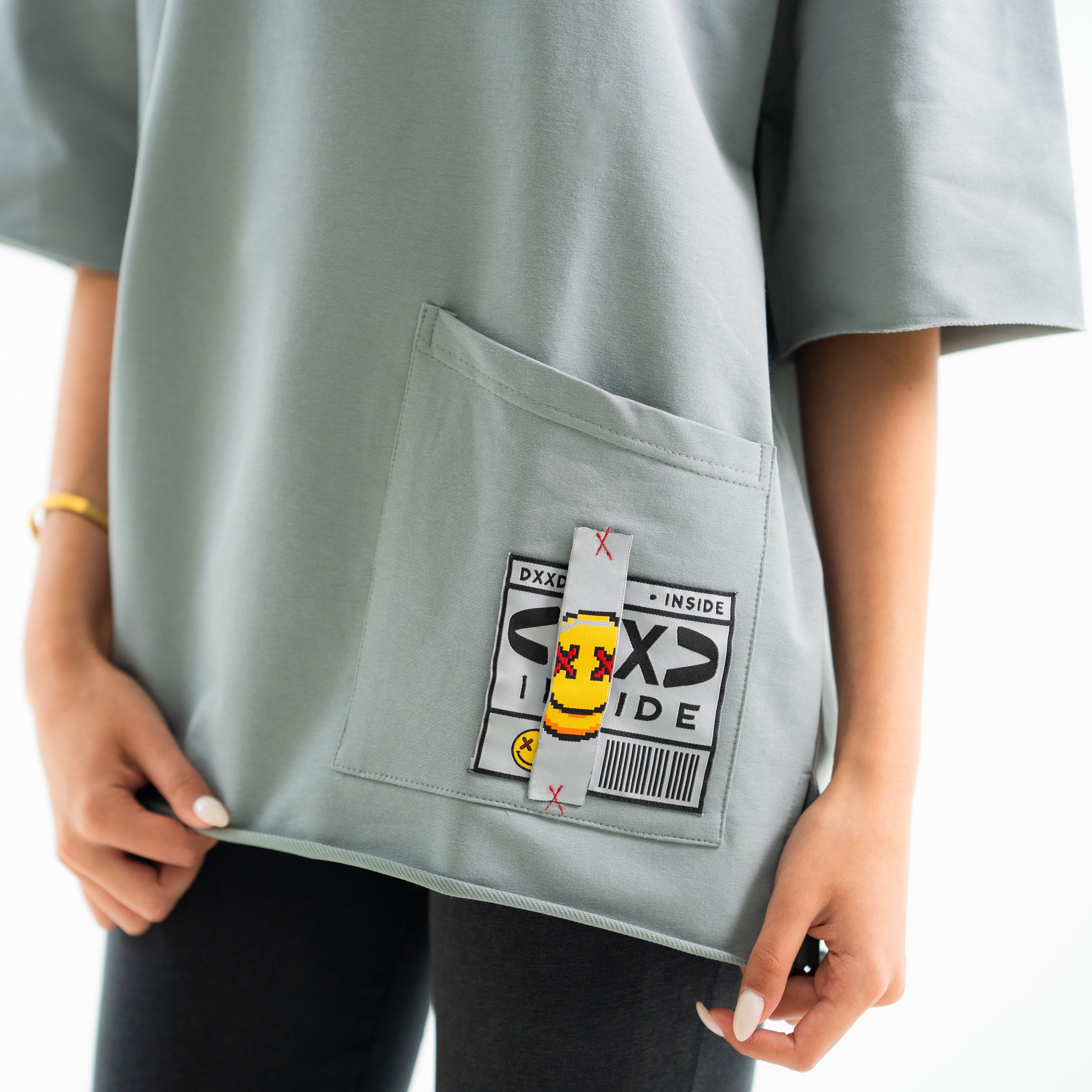 Light gray oversized t-shirt with a patch on the chest against a white background