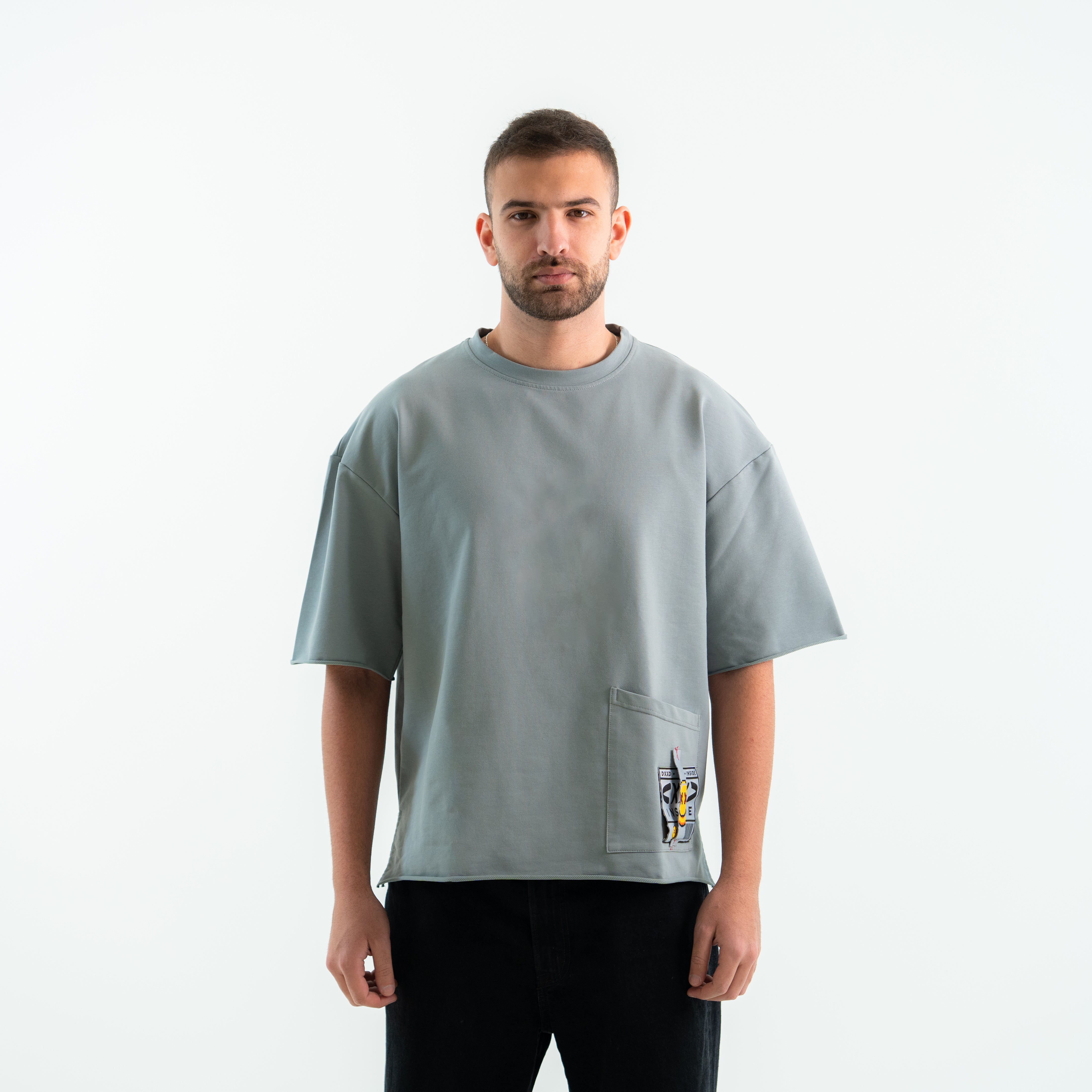 Man wearing a gray t-shirt with a pocket on a white background