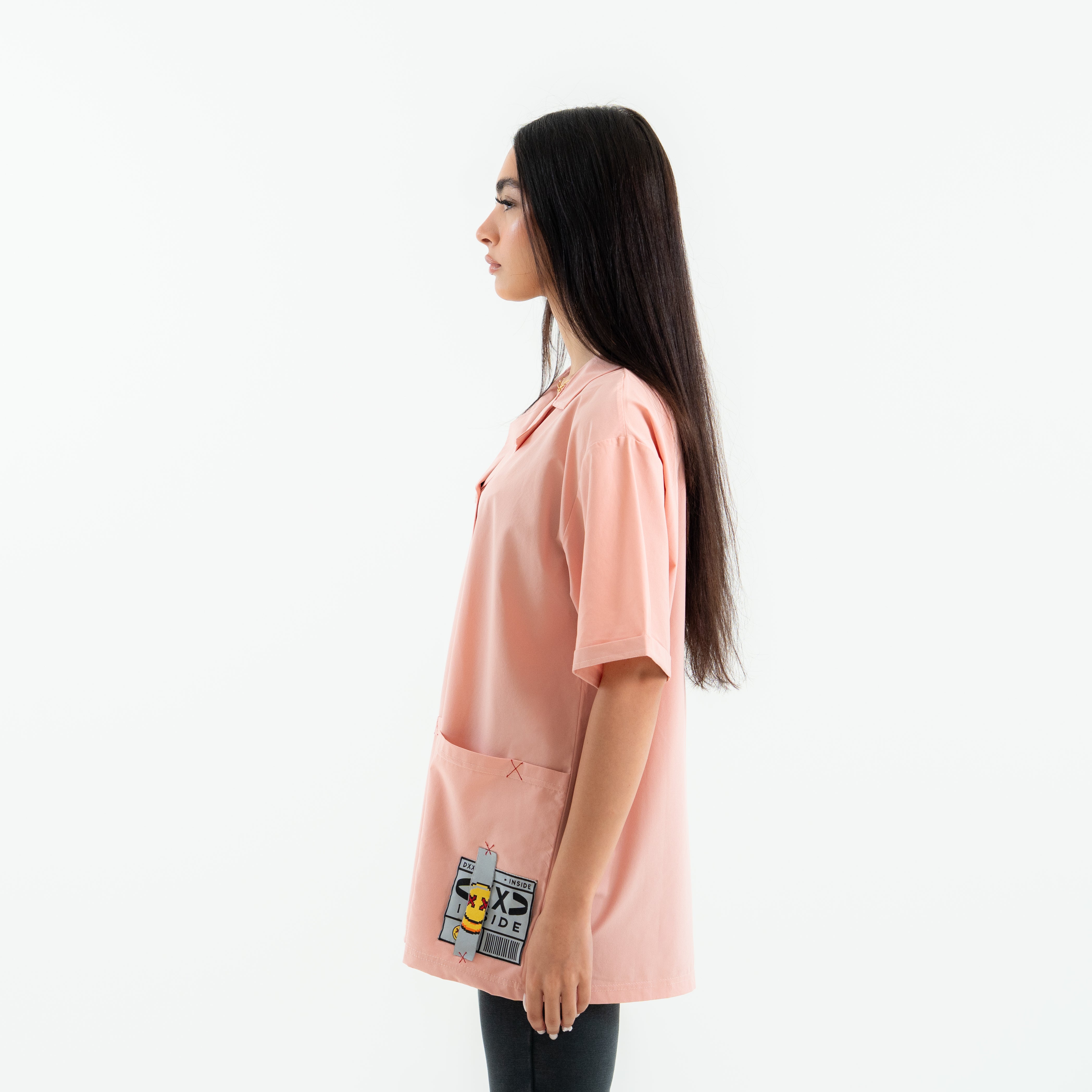 Woman wearing a pink shirt with a logo on a white background