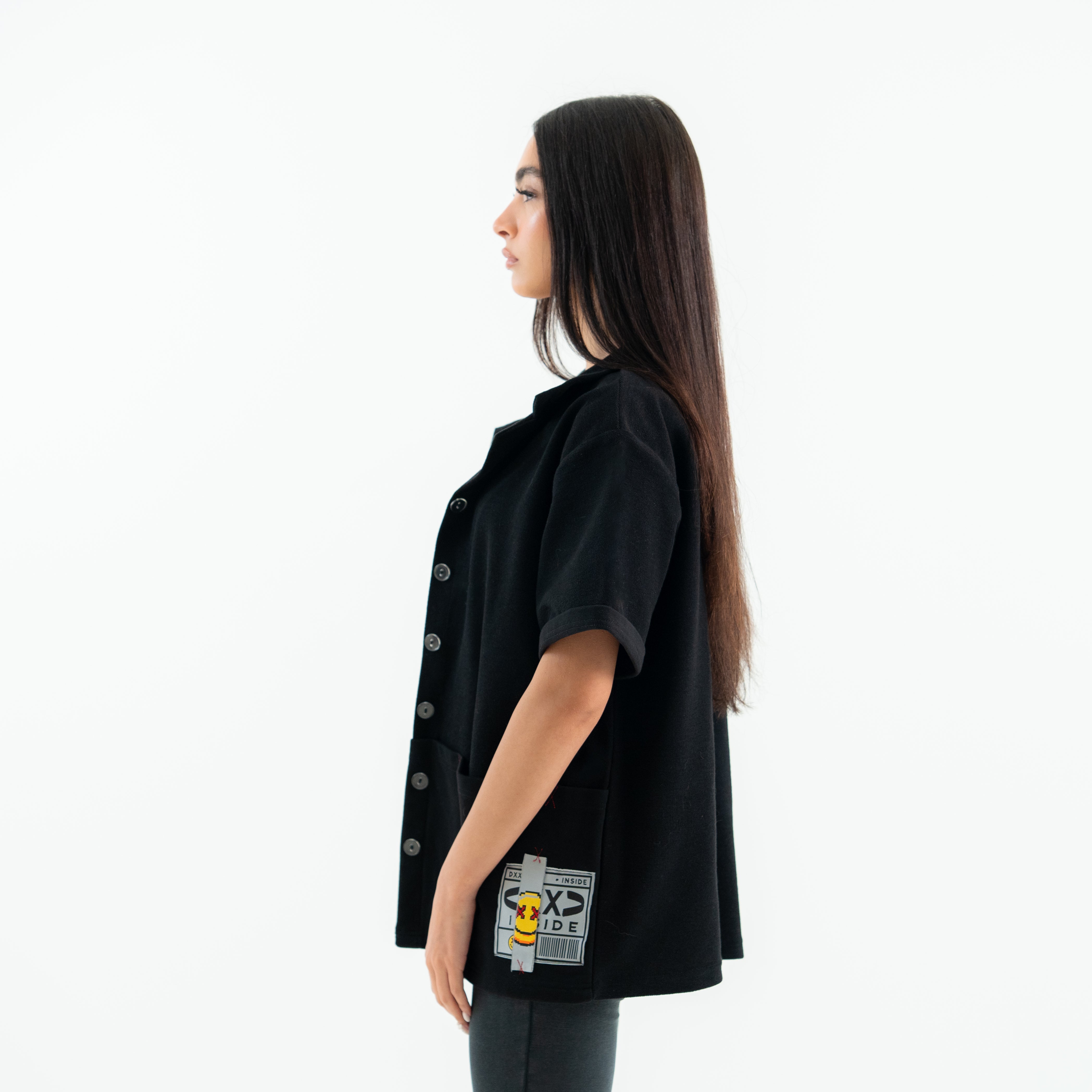 Woman wearing a black shirt with patches on a white background
