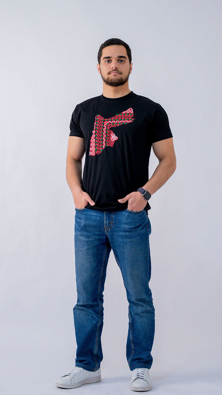 Man wearing a black t-shirt with a red logo and blue jeans on a white background
