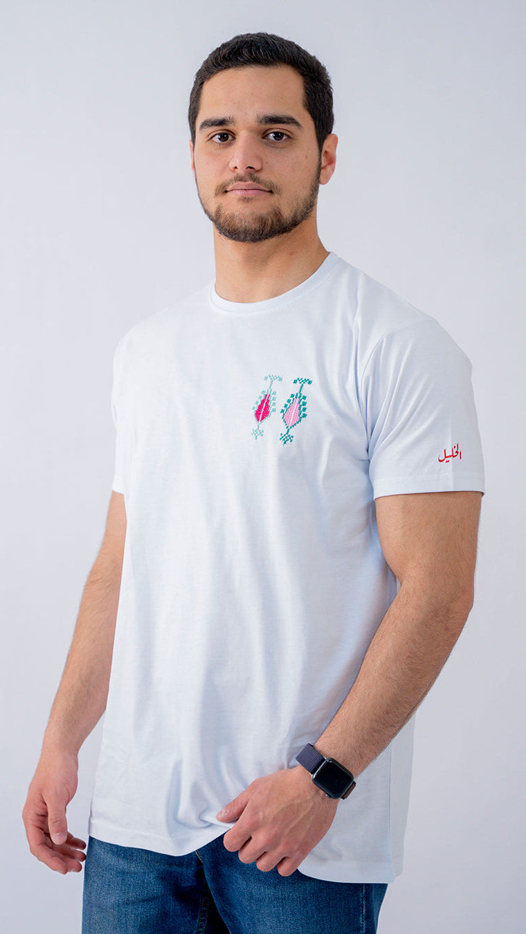 Man wearing a white t-shirt with colorful graphics on a plain background