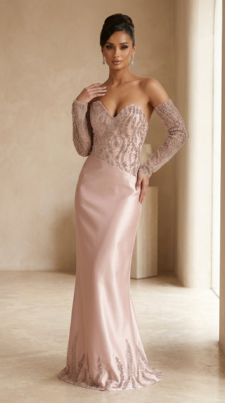 Woman wearing a pink evening gown with long sleeves in a softly lit room.