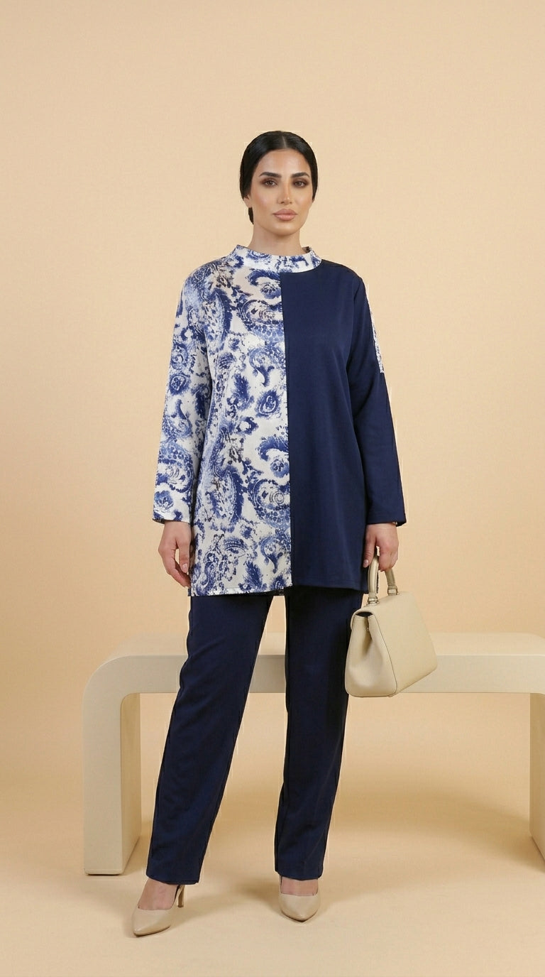 Woman wearing a navy blue and white patterned top with matching pants on a beige background
