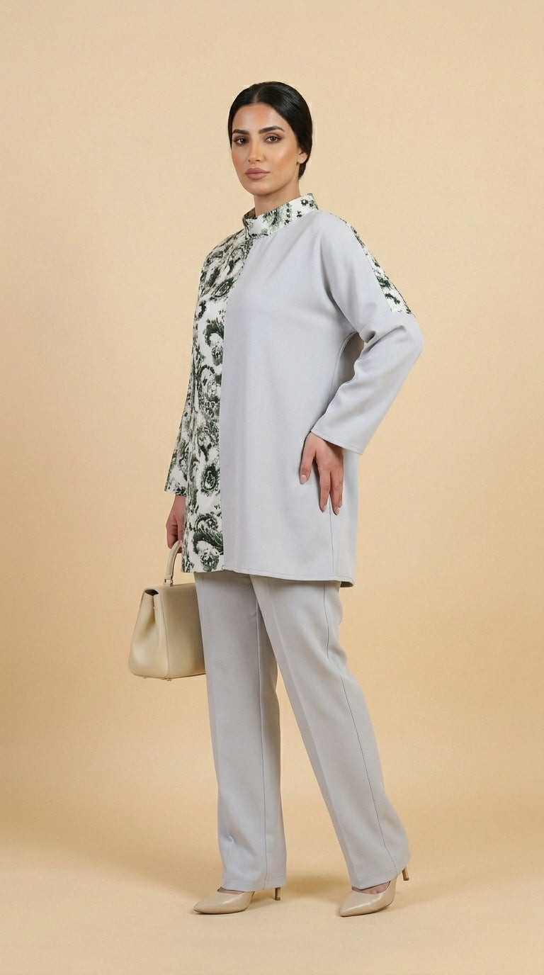 Woman wearing a light gray outfit with floral sleeves against a beige background