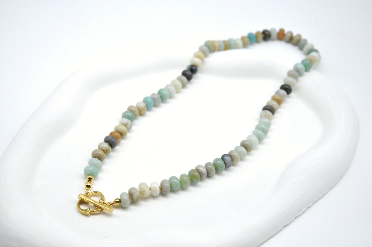 Necklace with small beads and a gold clasp on a white background