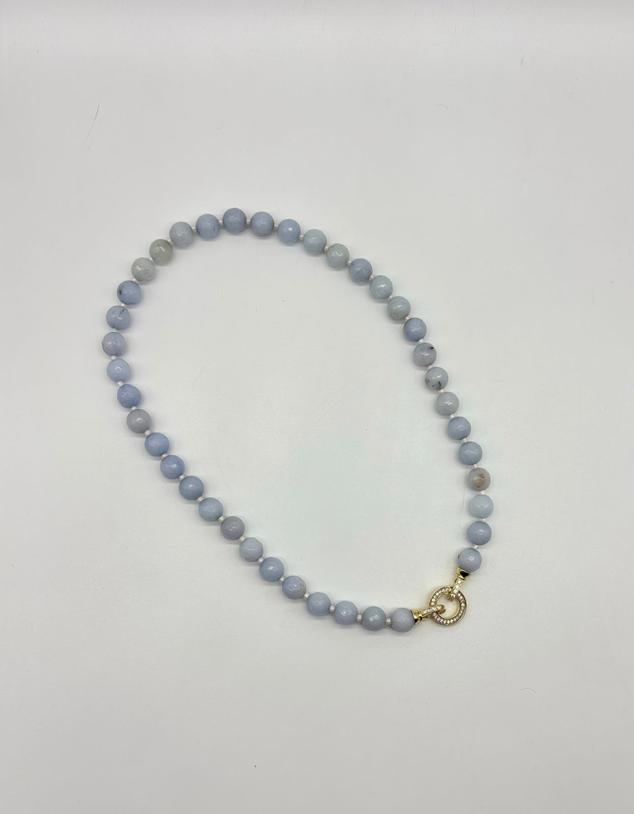 Beaded necklace with a gold clasp on a light gray background