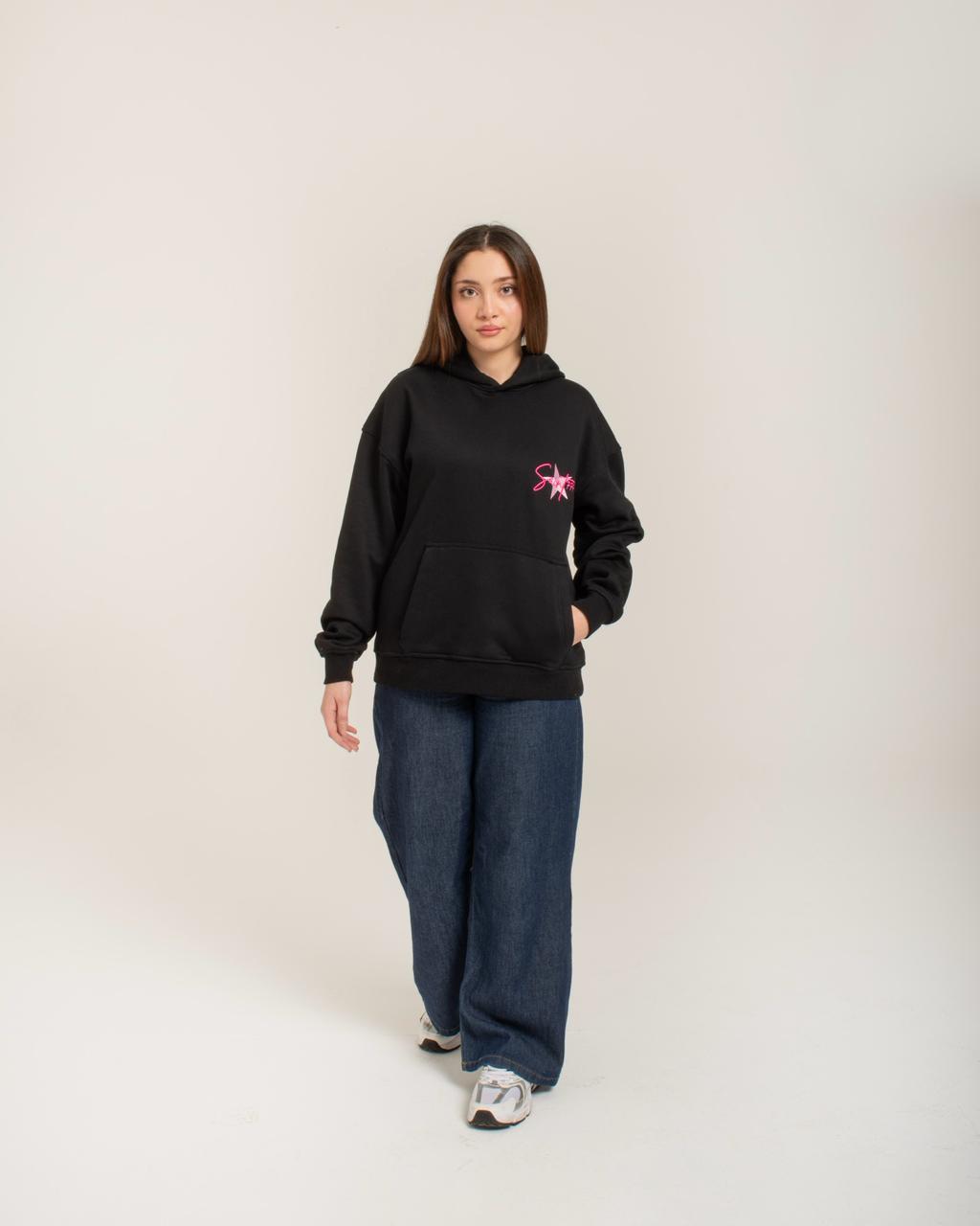 Person wearing a black hoodie with a pink logo on a white background