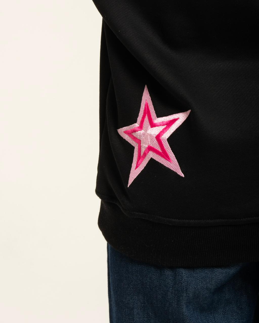 Black sweatshirt with a pink star design on a light gray background