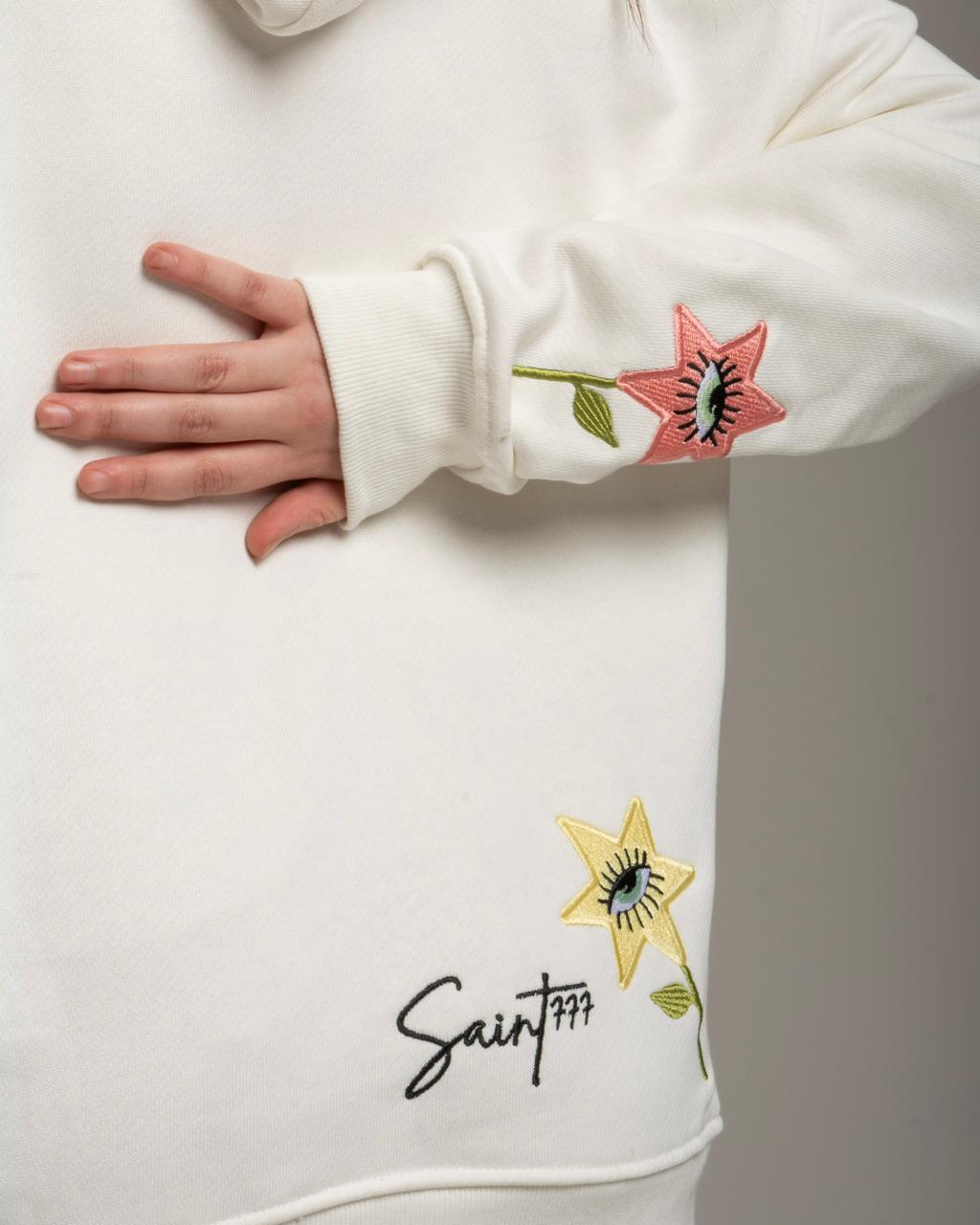 White hoodie with floral embroidery and 'Saint' branding on a plain background