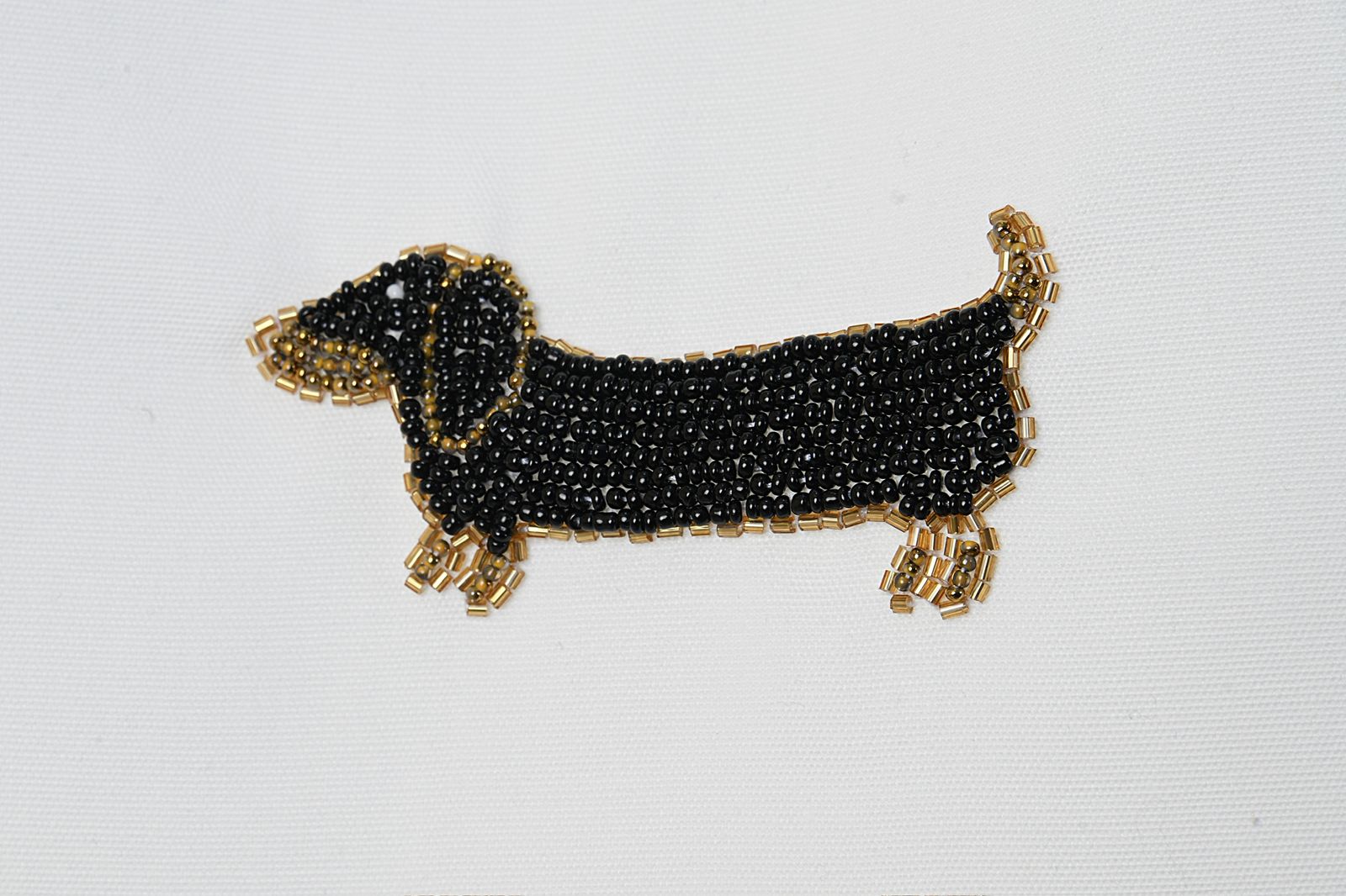 Black beaded dachshund dog charm on a white background