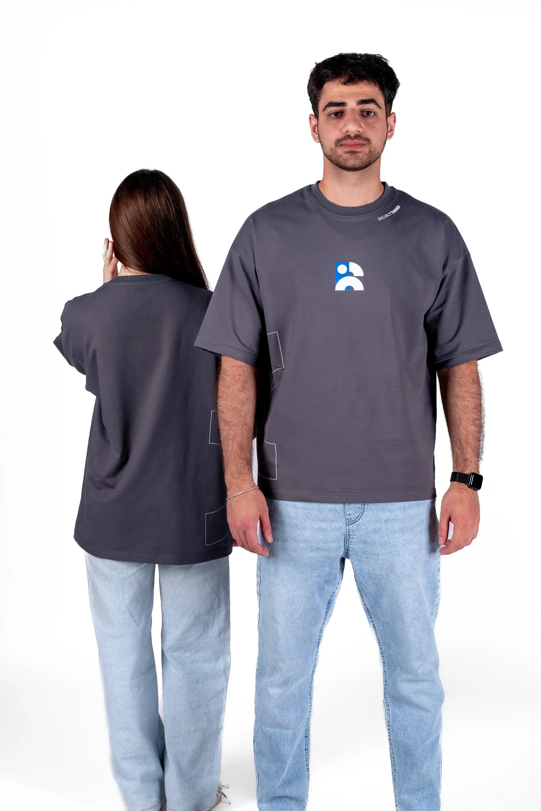 Two people wearing gray t-shirts with a logo, one facing forward and one facing backward, on a white background.