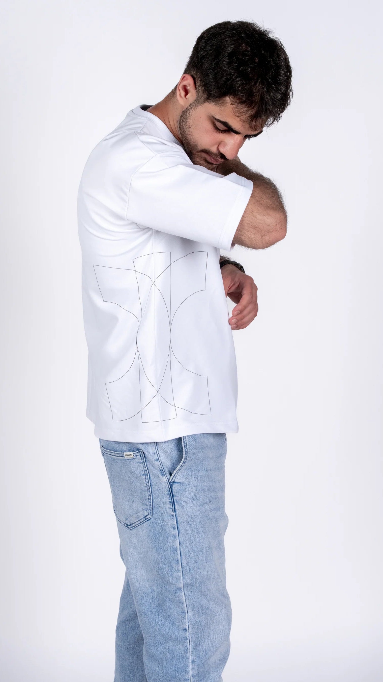 Man wearing a white jacket and light blue jeans on a white background