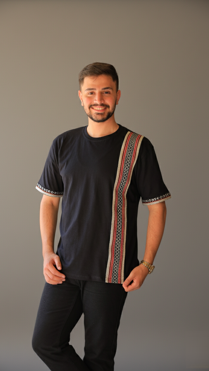 Man wearing a black shirt with a colorful patterned design on a gray background