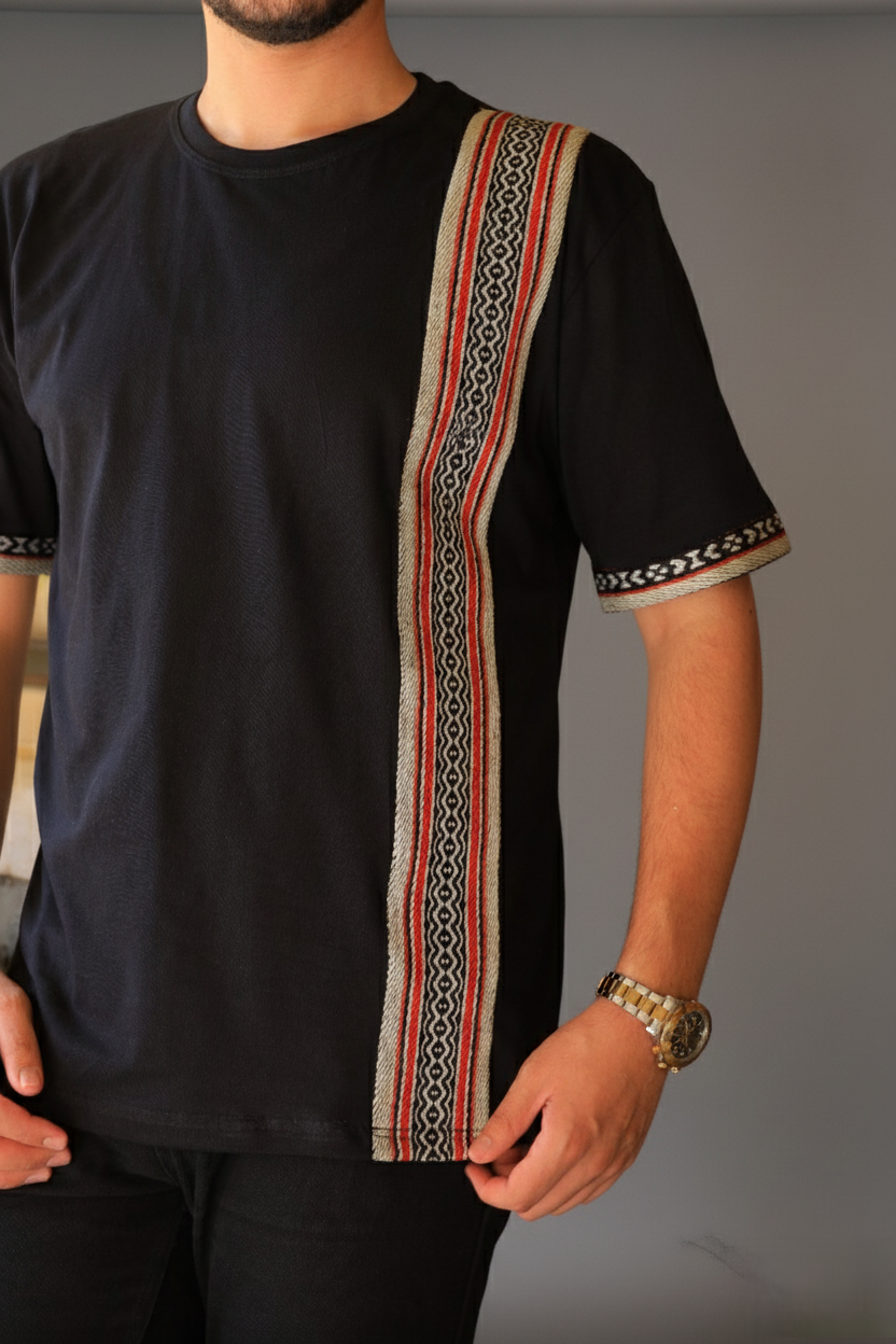 Person wearing a black t-shirt with a decorative pattern on a gray background