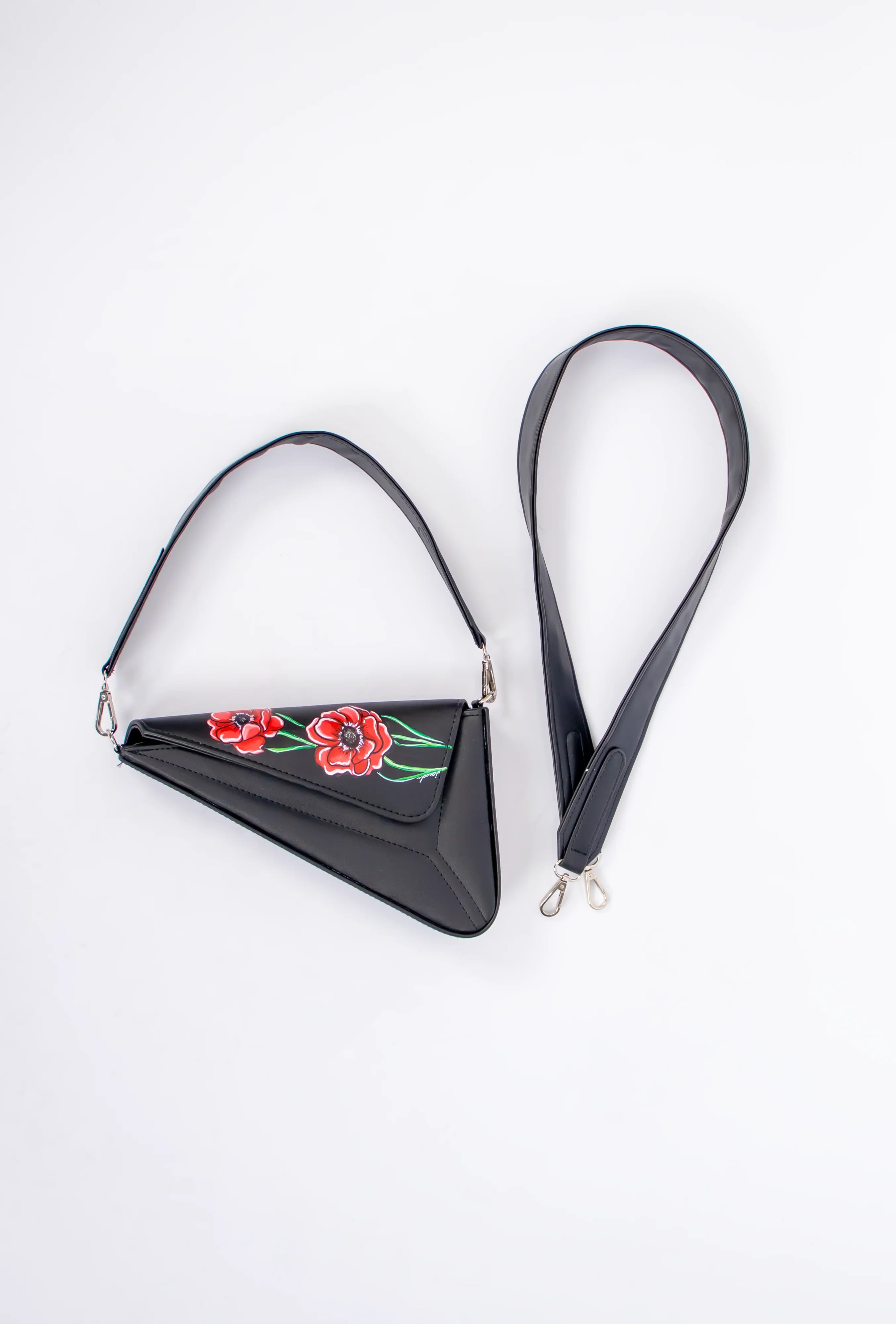Black triangular bag with floral embroidery on a white background
