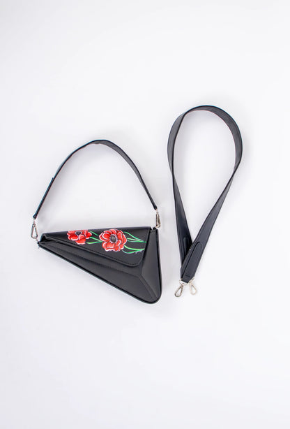 Black triangular bag with floral embroidery on a white background