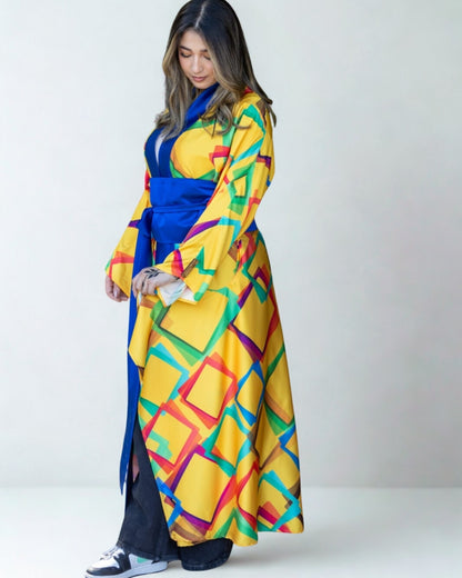Woman wearing a colorful geometric patterned dress with a blue belt on a white background