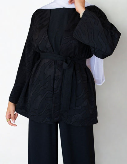 Person wearing a black outfit with a white background