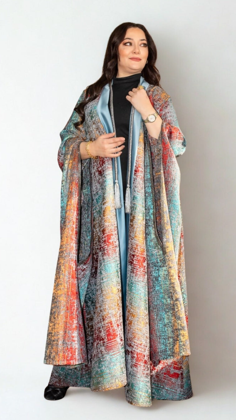 Woman wearing a long, colorful scarf against a white background