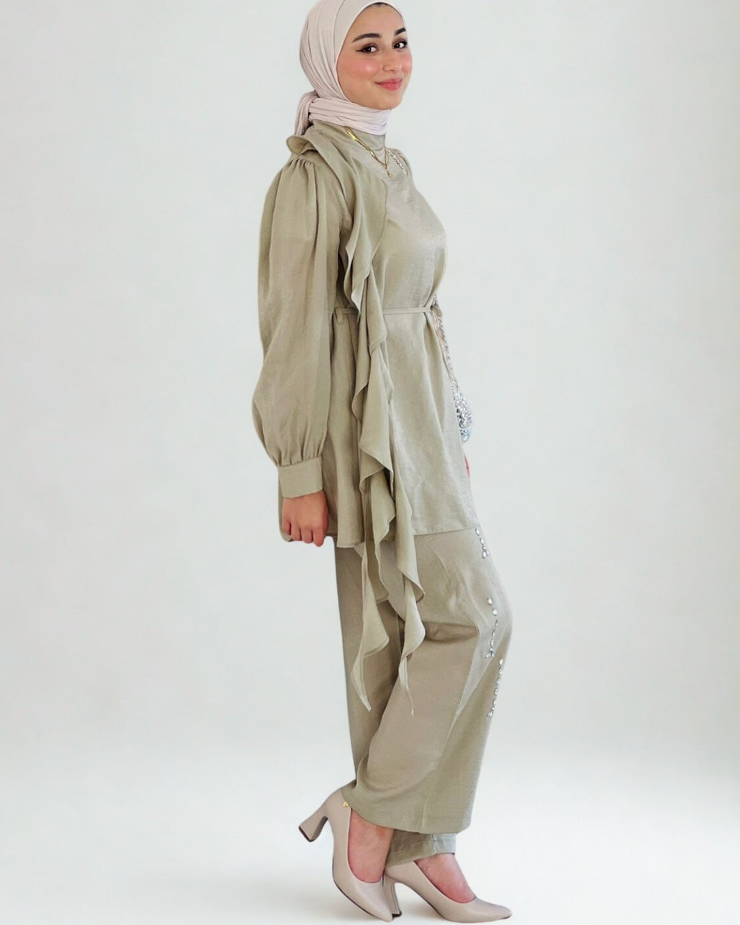 Woman wearing a beige outfit with a hijab on a white background