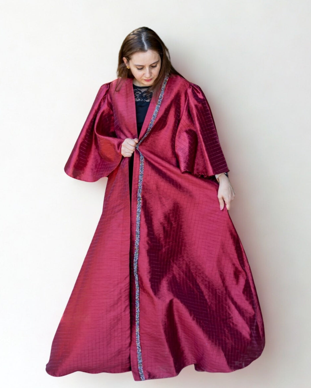 Woman wearing a long burgundy robe against a white background