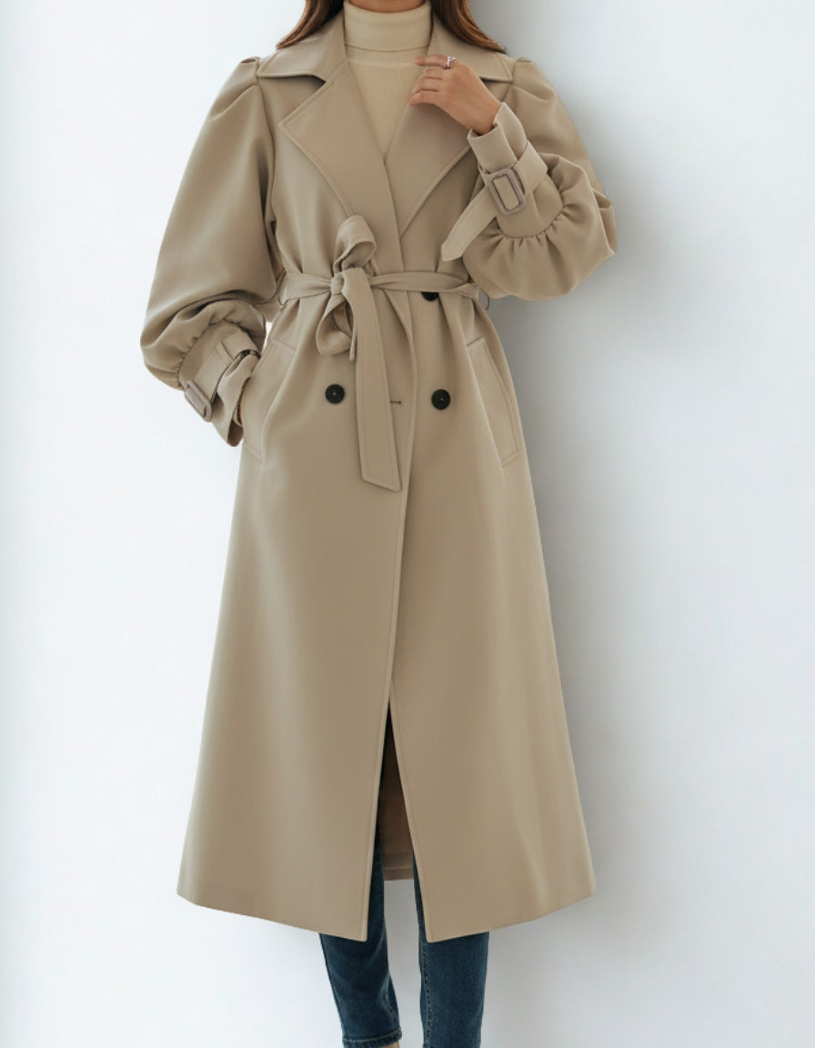 Beige trench coat worn by a person on a white background