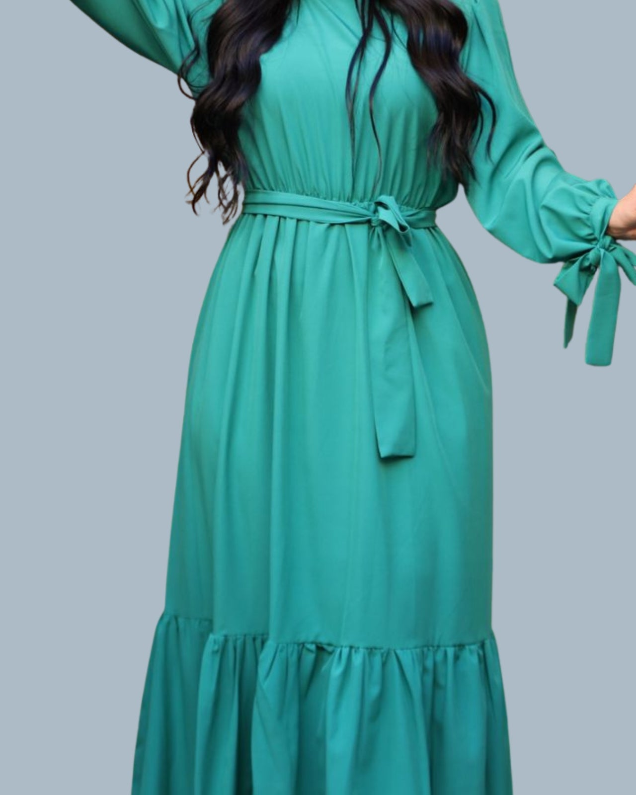Green dress with long sleeves and a belt on a gray background