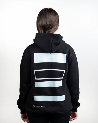 Person wearing a black hoodie with light blue geometric patterns on the back against a white background