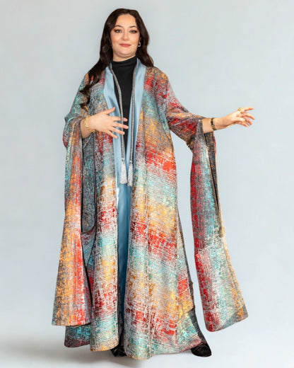 Woman wearing a colorful patterned coat on a plain background