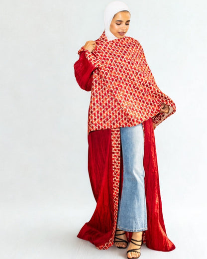 Woman wearing a red and white patterned top with a long red scarf over her shoulders on a white background