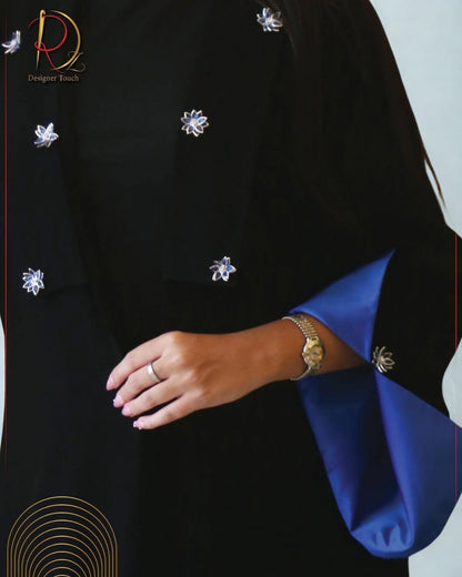 Black garment with blue accents and decorative elements, featuring a brand logo.