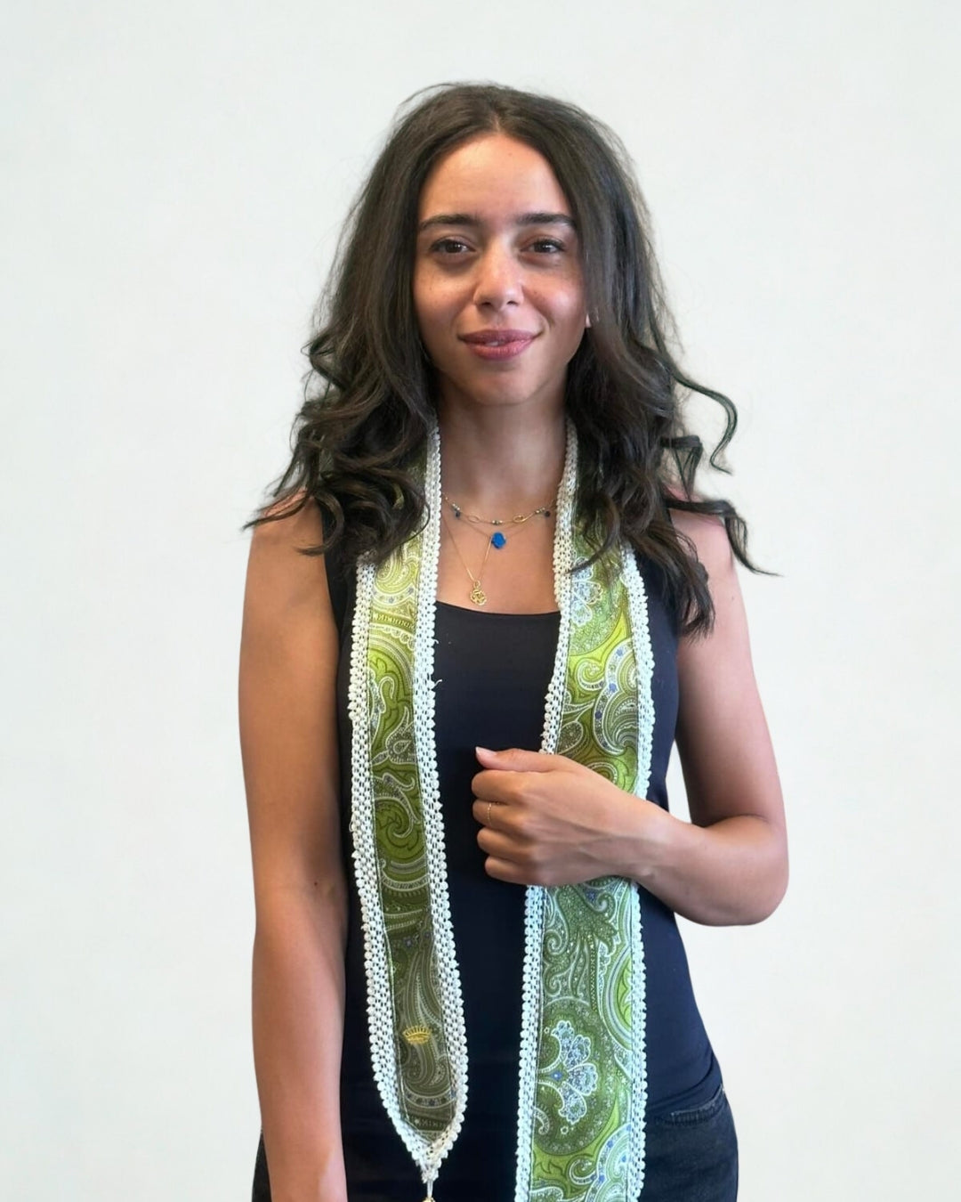 Woman wearing a long, patterned scarf against a plain background