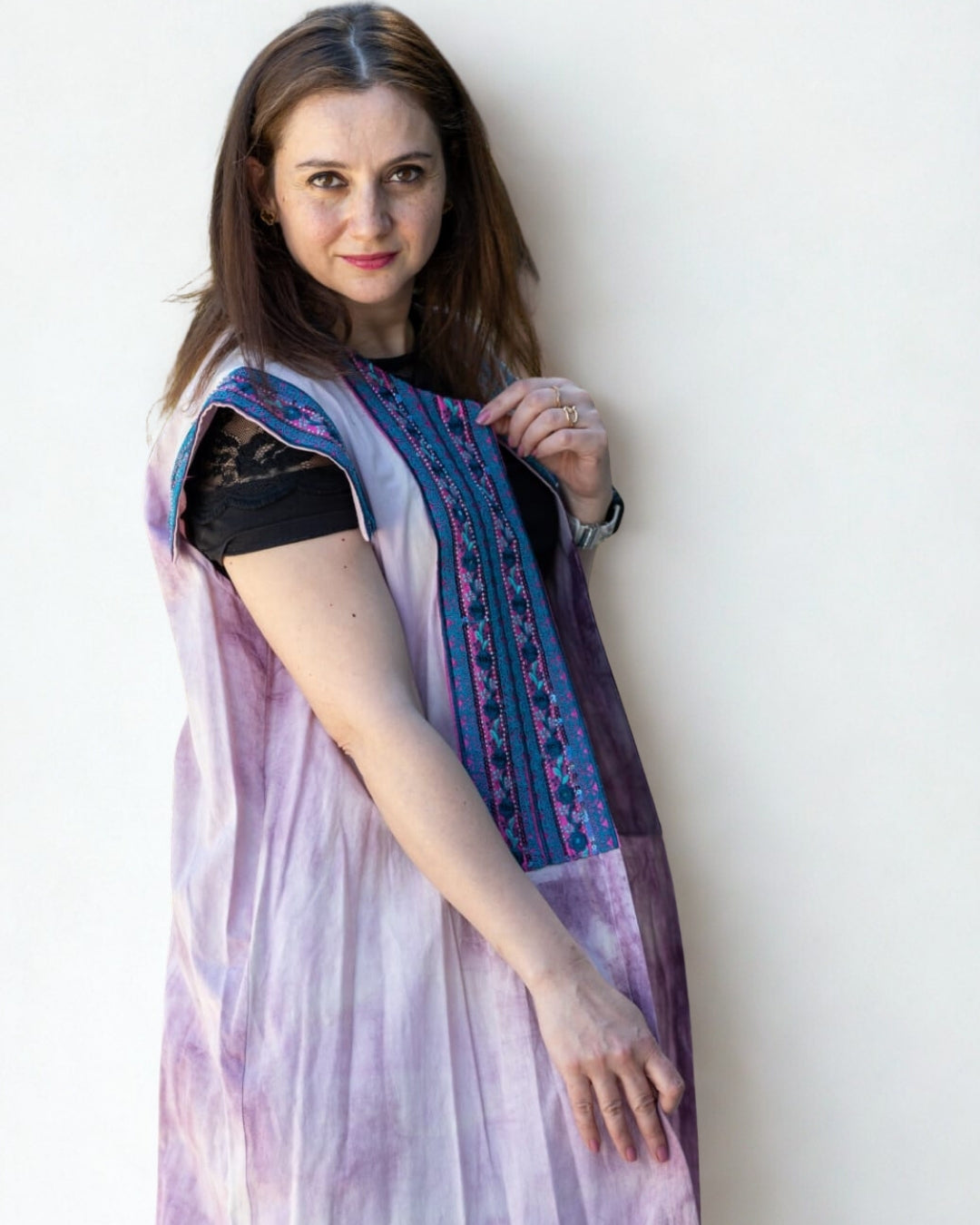 Woman wearing a light purple saree with a blue border against a white background