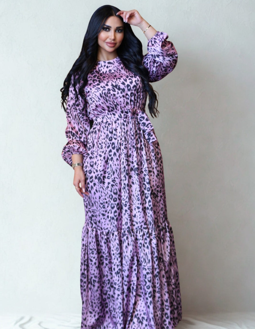 Woman wearing a purple leopard print dress against a plain background