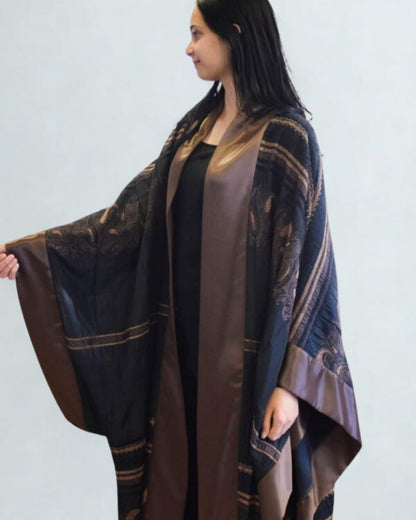 Woman wearing a patterned brown and blue garment against a plain background