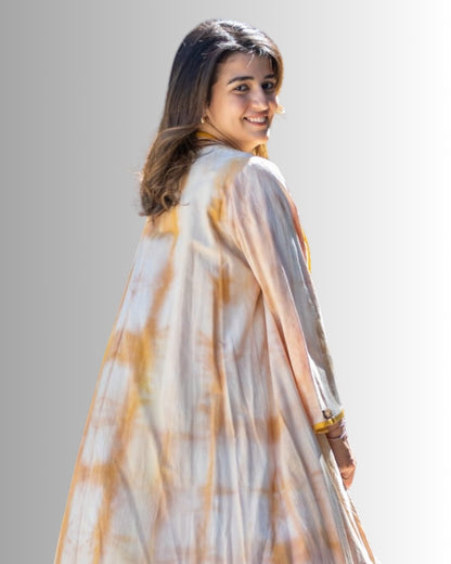 Woman wearing a tie-dye dress with a plain background