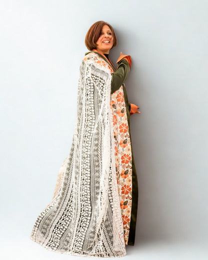 Woman wearing a long, patterned dress against a plain background