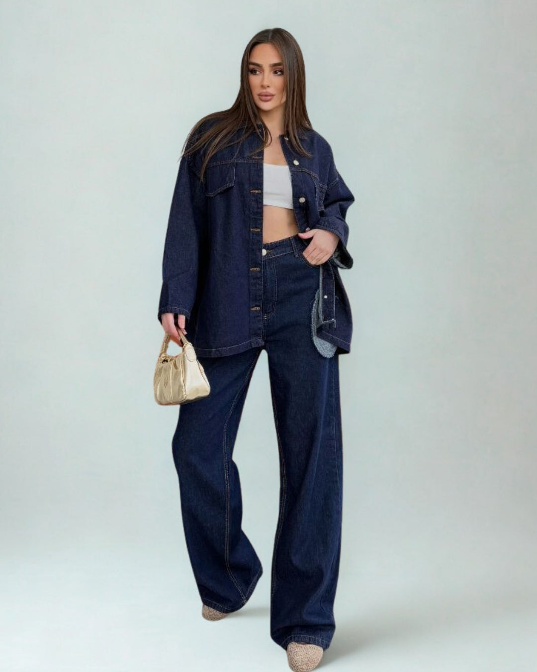 Woman wearing a denim outfit with a plain background