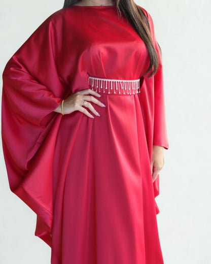 Red dress with a beaded waistband on a plain background
