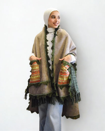 Woman wearing a patterned shawl over a plain background