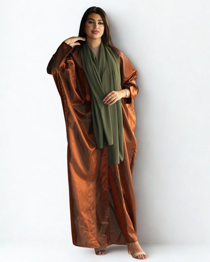 Woman wearing a long brown garment with a green scarf on a white background