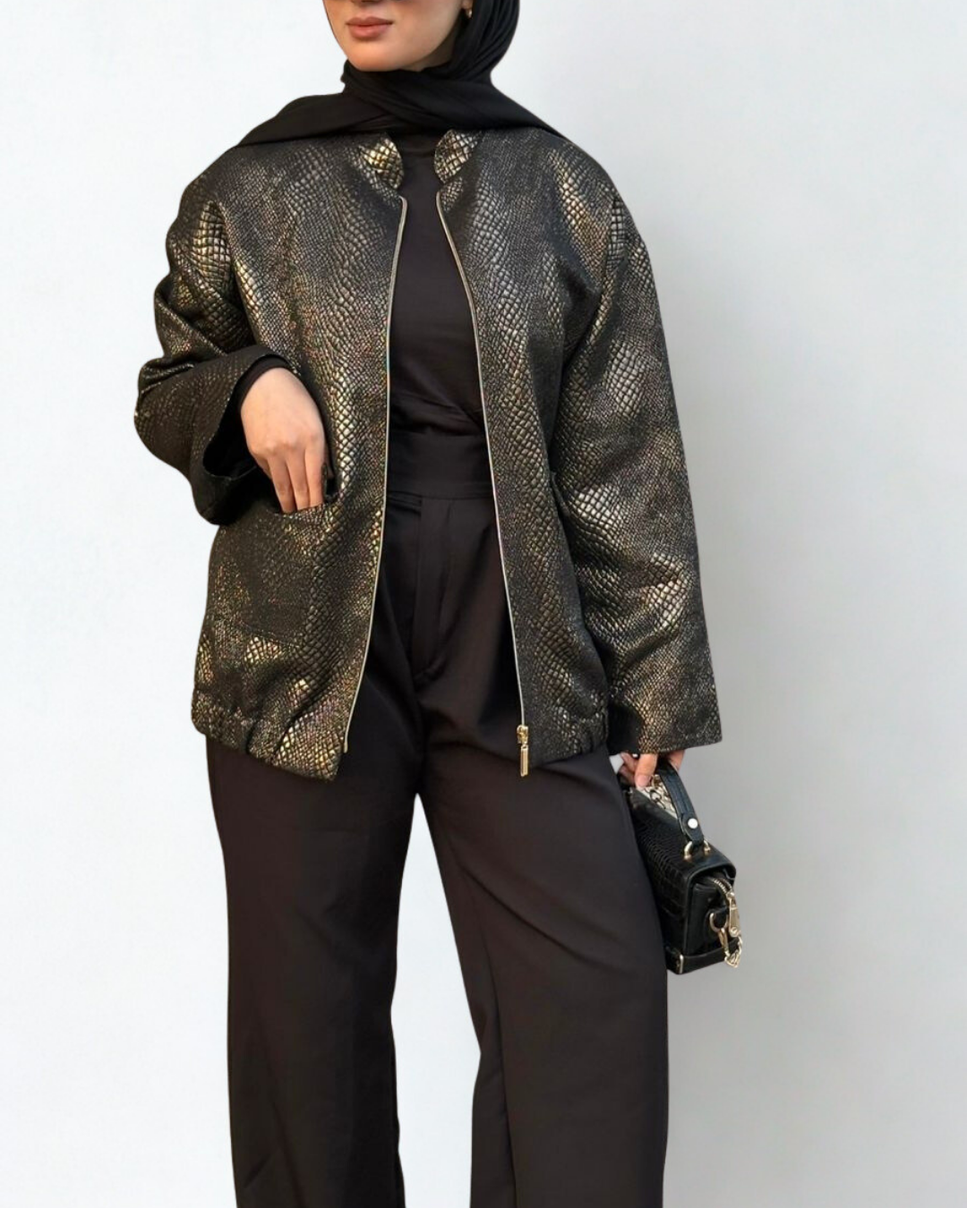 Person wearing a patterned jacket over a black outfit on a white background