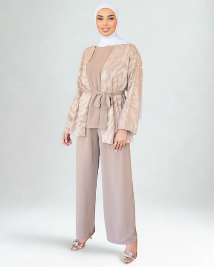 Woman wearing a beige outfit with a matching hijab on a white background