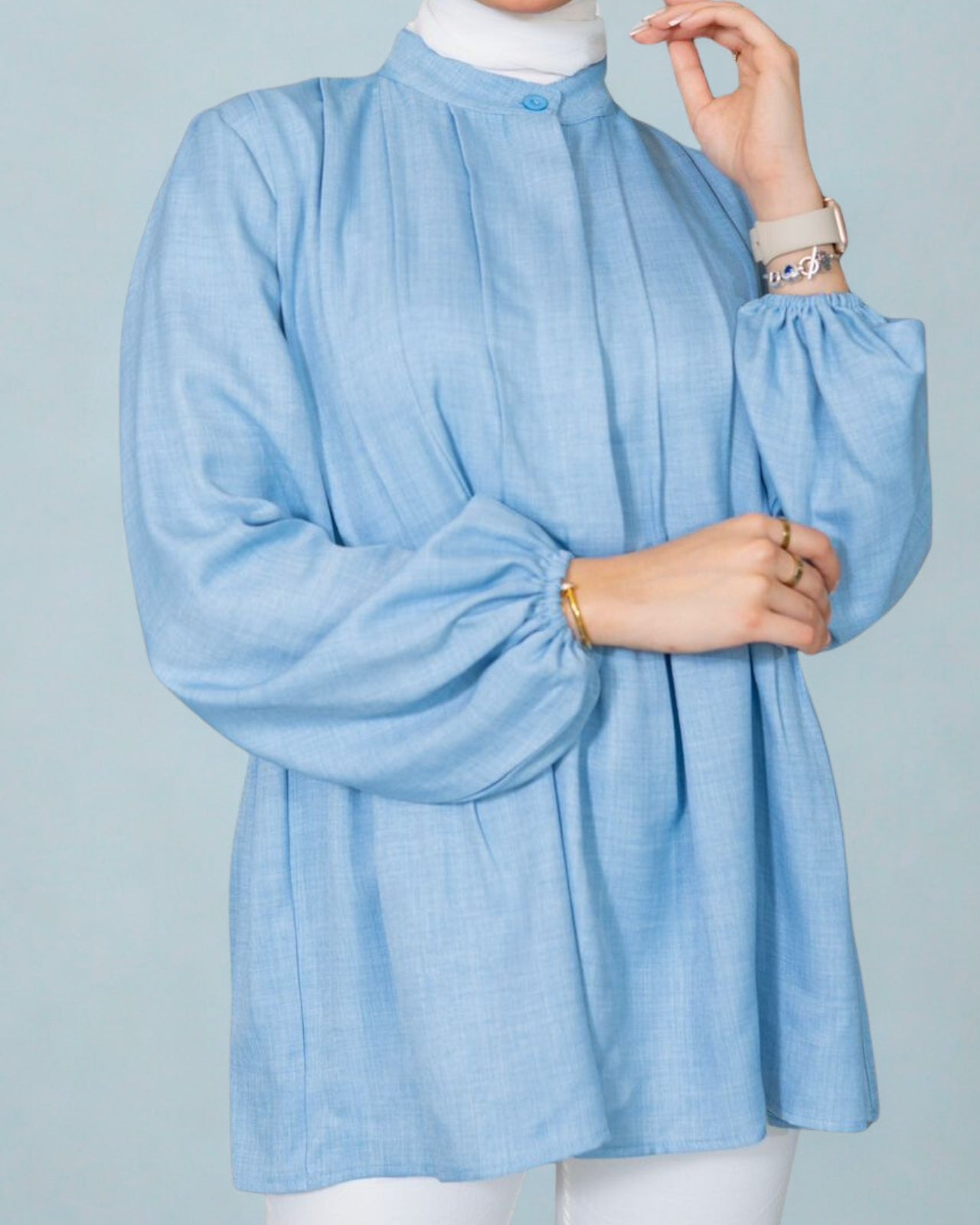 Light blue blouse worn by a person on a light gray background
