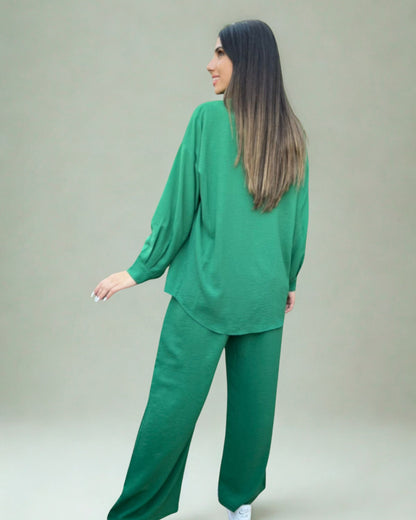 Woman wearing a green outfit against a plain background